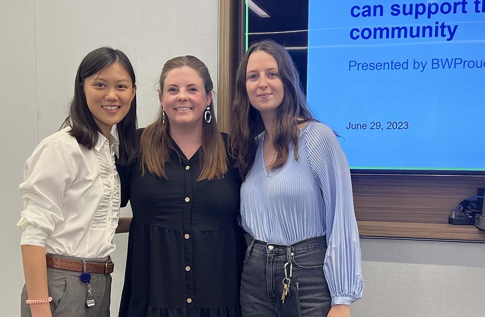 3 female attendees smiling together at the event.