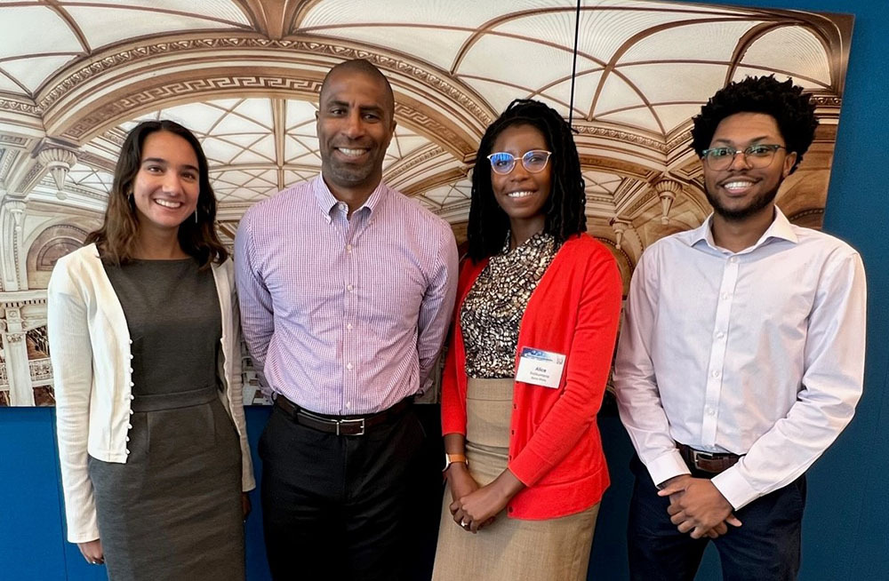 Dr. Gary Hoover standing and smiling with three other Bates White employees