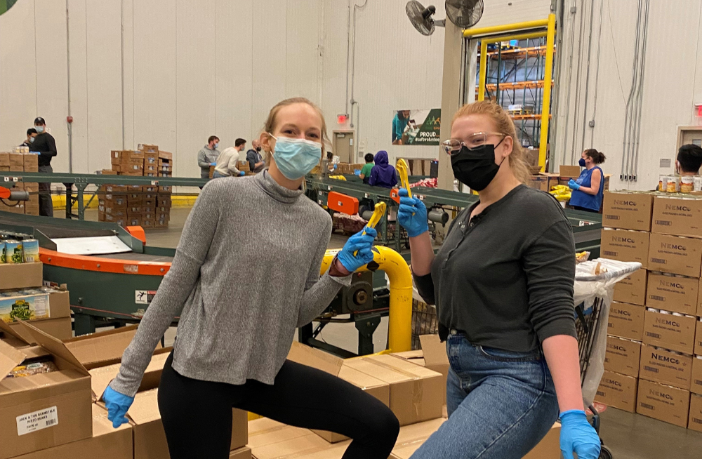 Two young women wearing masks, standing together and holding box cutters.