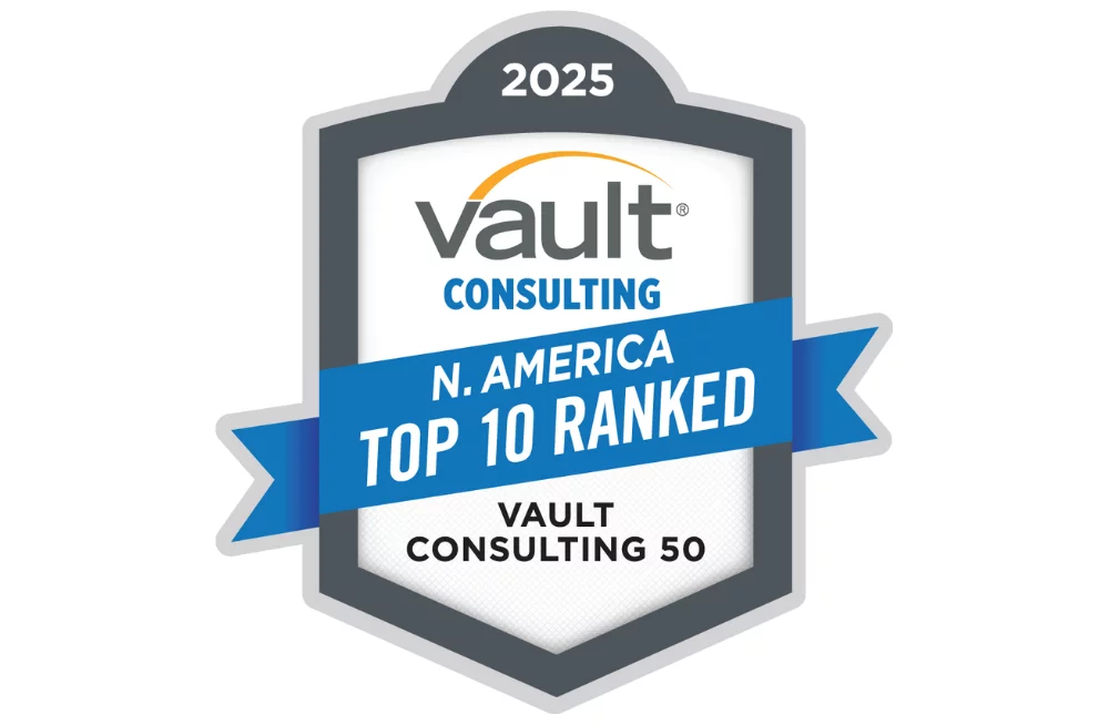 An award shield that reads: 2025 Vault Consulting N. America Top 10 Ranked Vault Consulting 50. The words “N. America Top 10 Ranked” are on a blue ribbon on top of the middle of the shield.