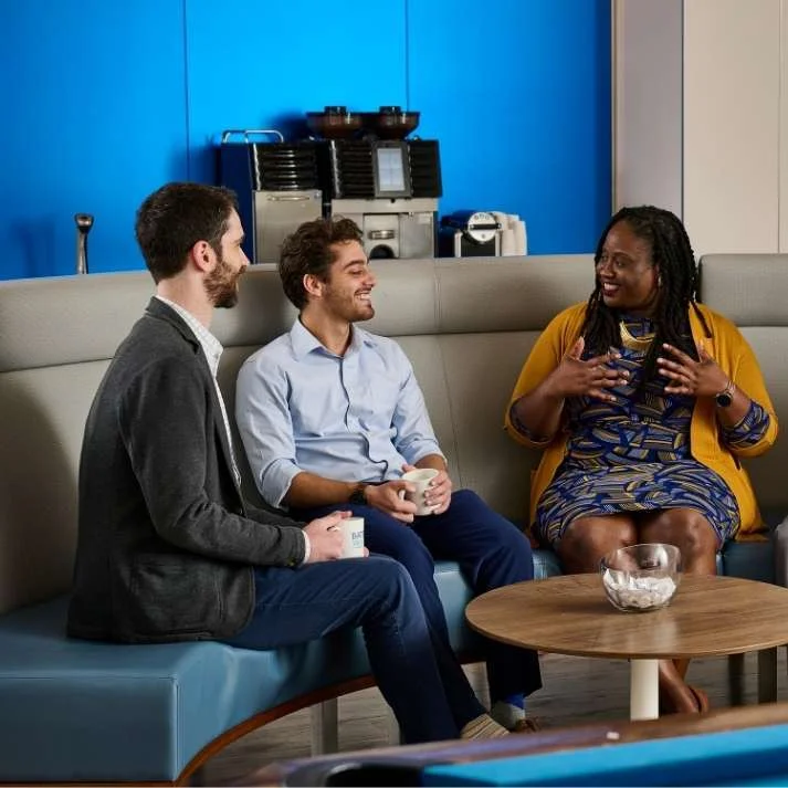 Three Bates White employees sit down for coffee in the Micro Bistro